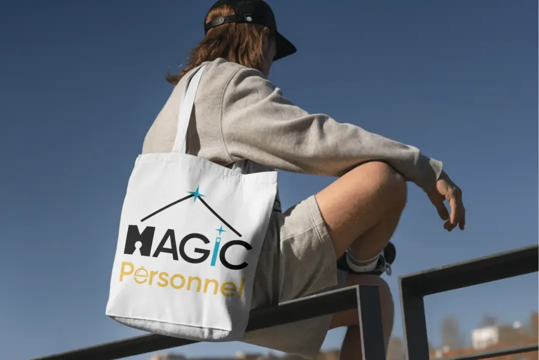 Brand identity for a housekeeping business: a black, gold and blue logo with a keyhole M and a magic wand, printed on a white tote bag