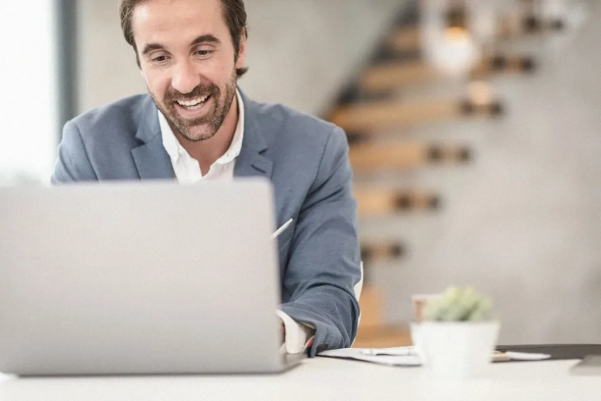 A smiling business owner working on a laptop