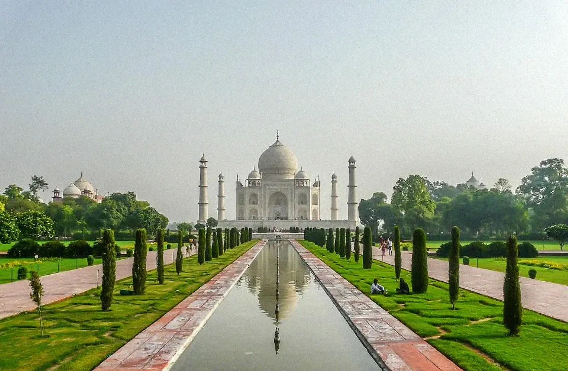 The Taj Mahal reflected in a long pool with gardens