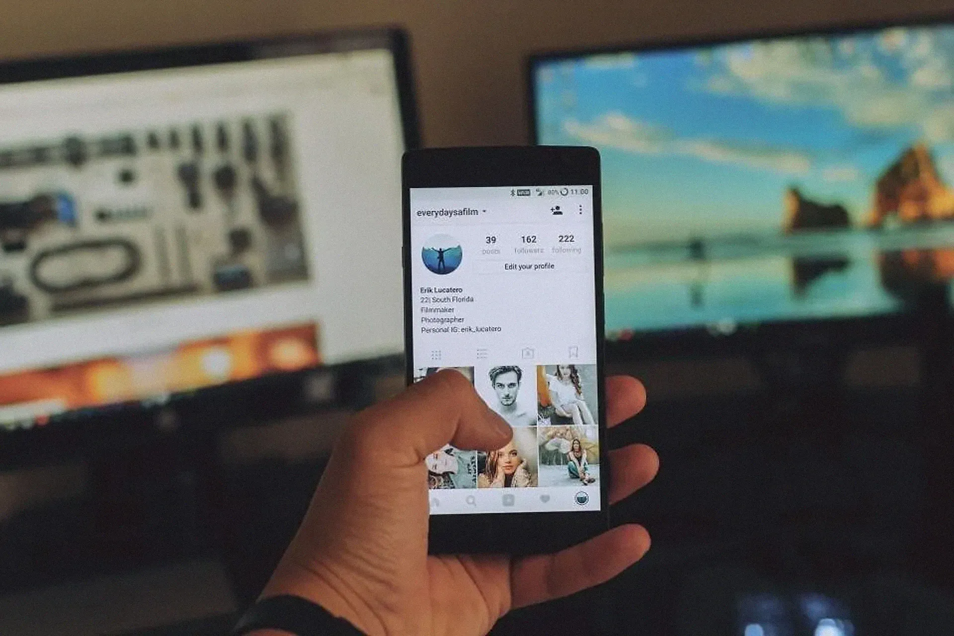 A hand holding a smartphone showing a social media feed