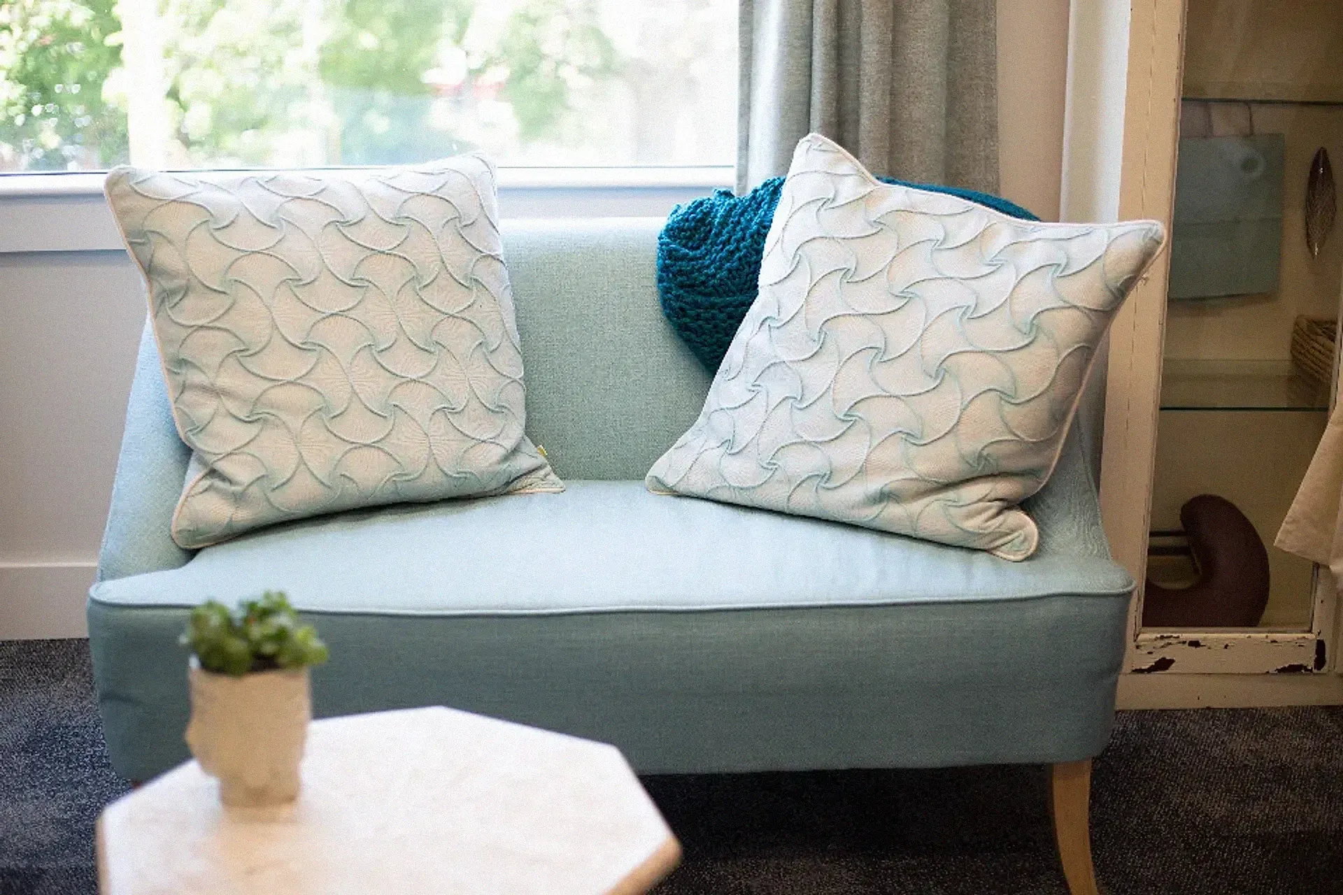 A calm, well-designed interior with a sofa, cushions and natural light