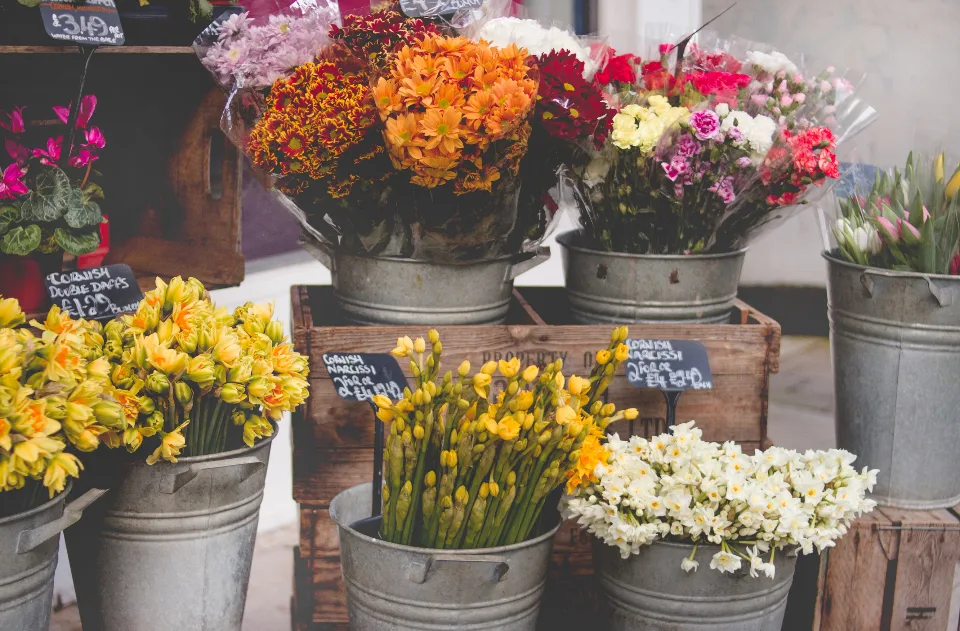 Buckets of fresh flowers outside a small shop
