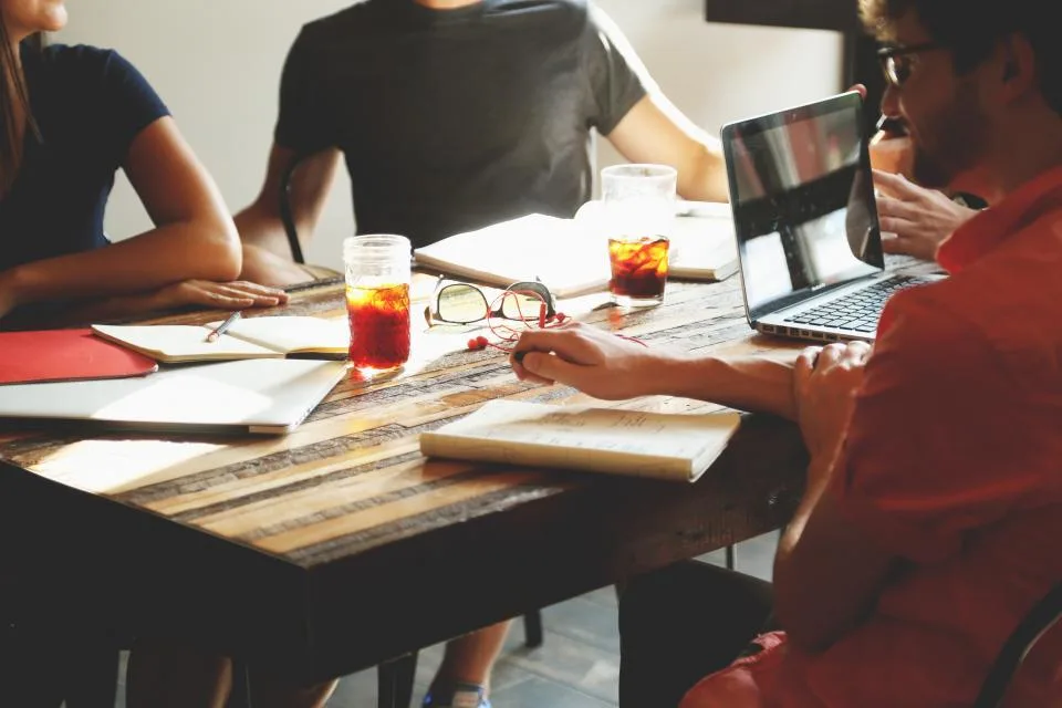 A team working around a table with laptops and notebooks