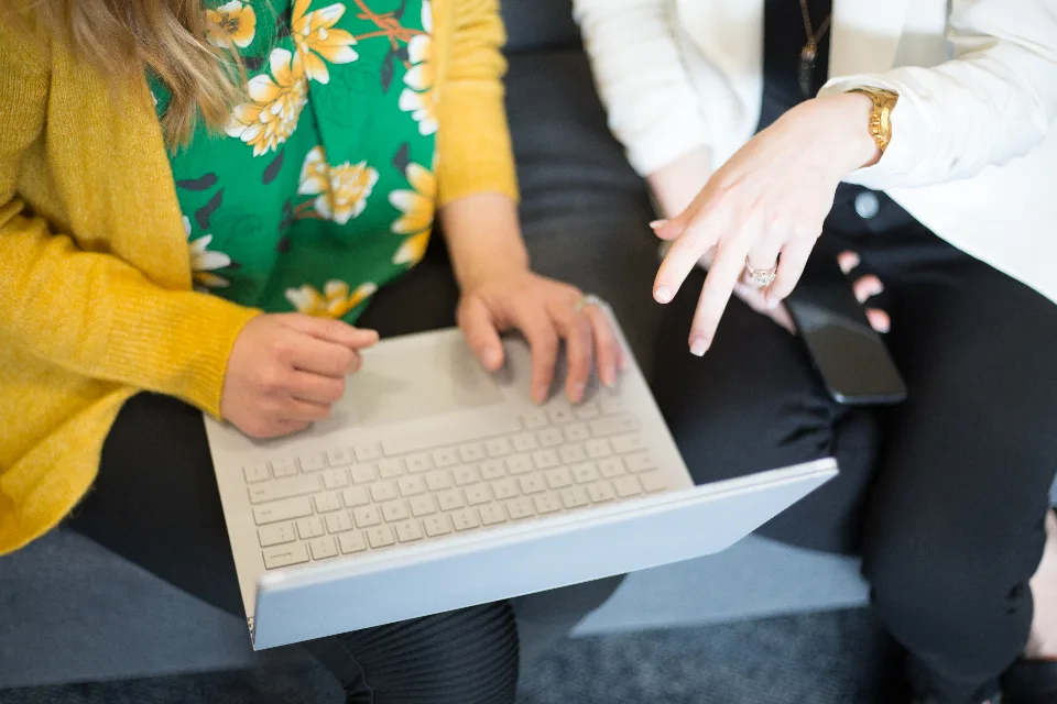 Two people working together on a laptop