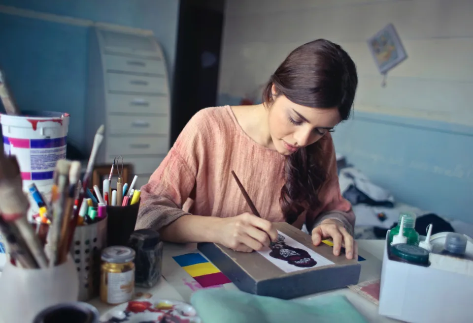 A designer painting at a busy desk